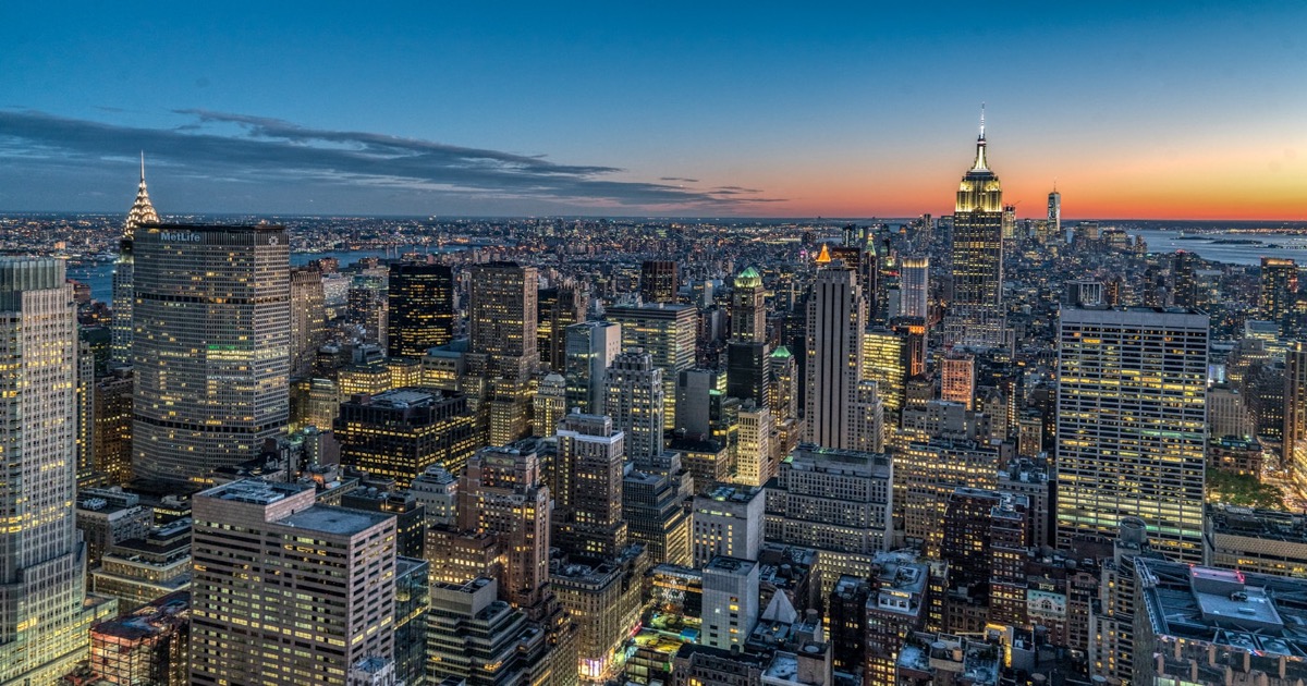 Aerial view of New York City skyline illuminated at night with skyscrapers and city lights