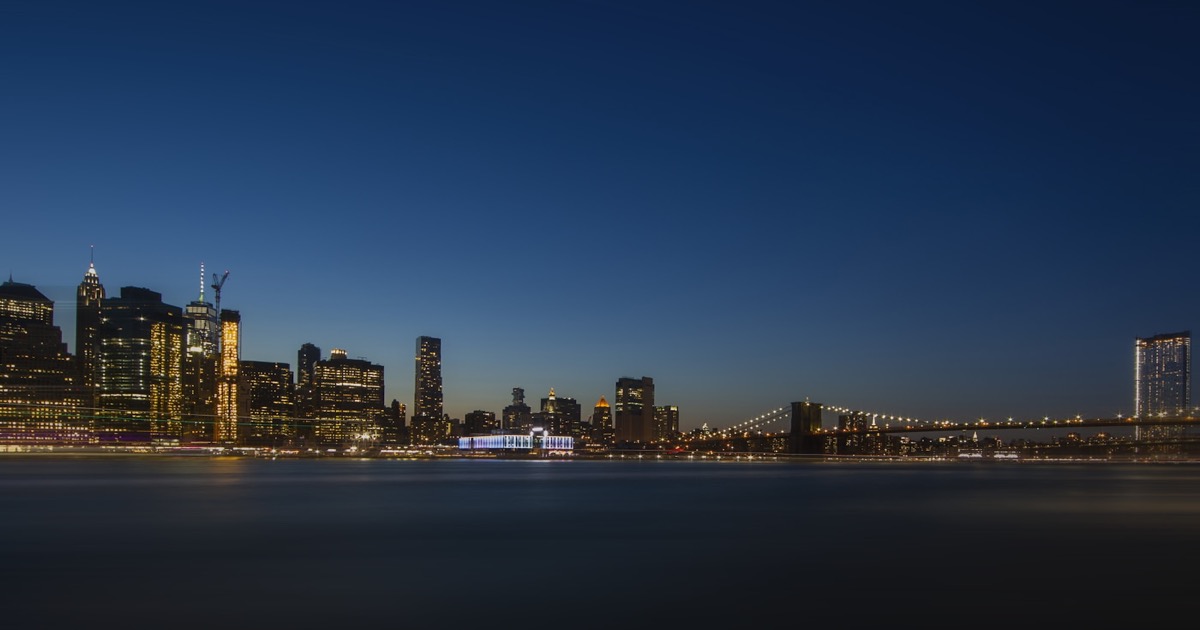 Nighttime cityscape of a financial district with glowing lights, representing the close of the last trading session before Good Friday, April 2, 2026