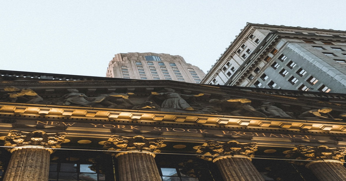 New York Stock Exchange facade at dusk with skyscrapers in the background