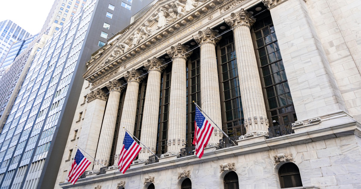 New York Stock Exchange building with American flags on Wall Street