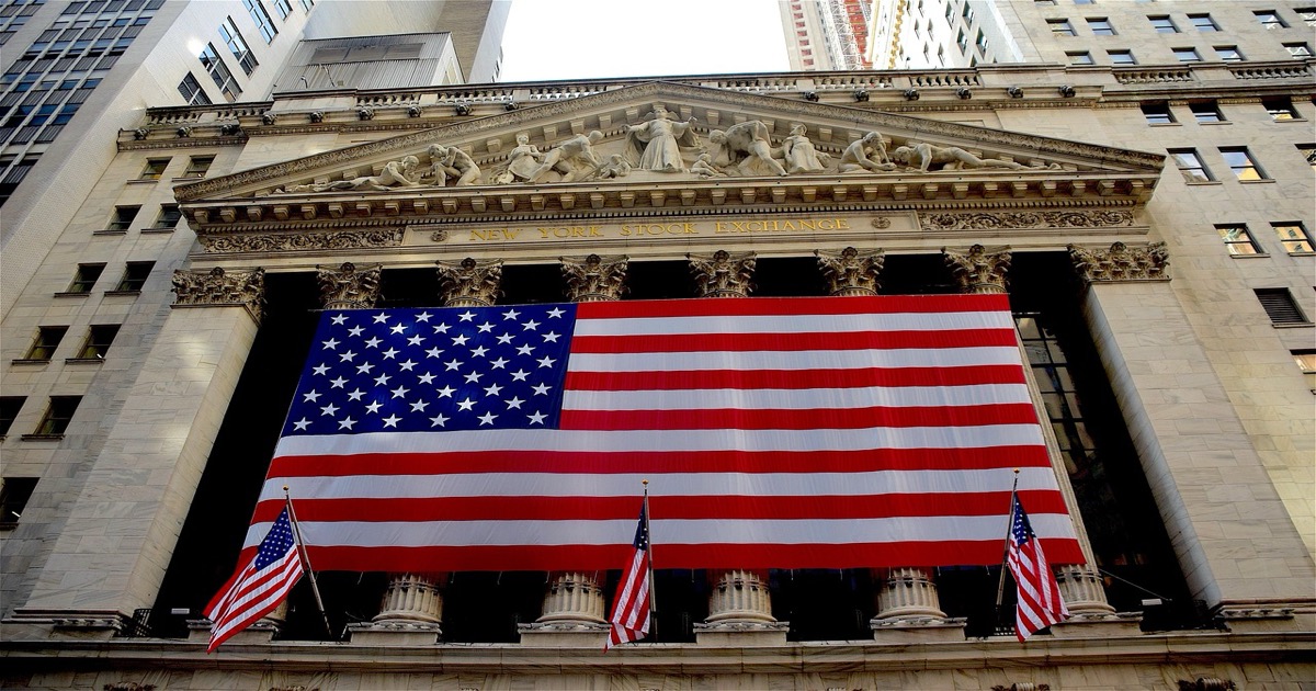 New York Stock Exchange building on Wall Street with American flags