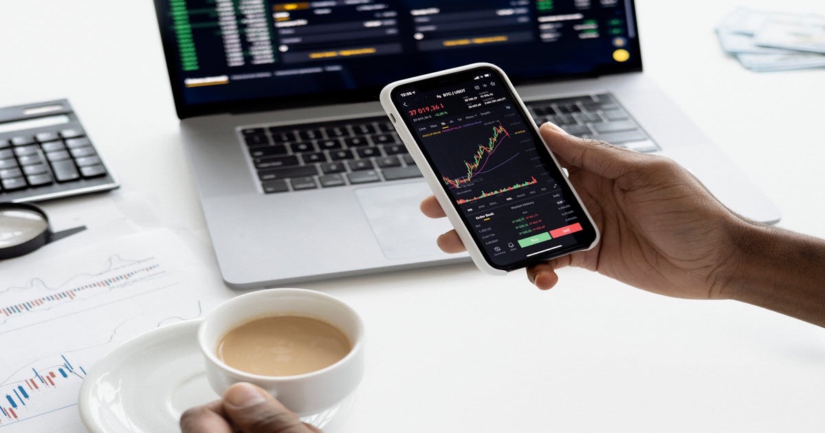 Trader reviewing market data on phone and tablet &mdash; yields climb into Nvidia earnings eve.