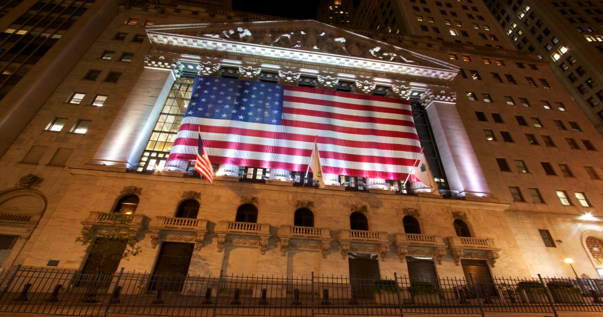 Nighttime view of the New York Stock Exchange with an American flag for the May 21 market wrap.