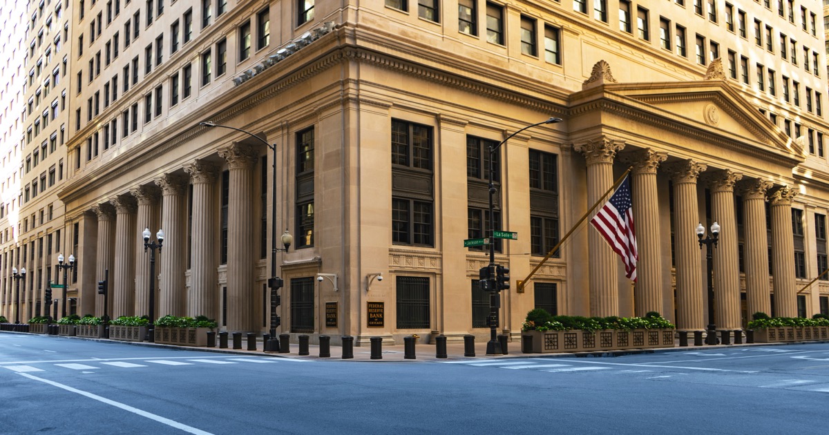 Federal Reserve building with columns and American flag at dusk
