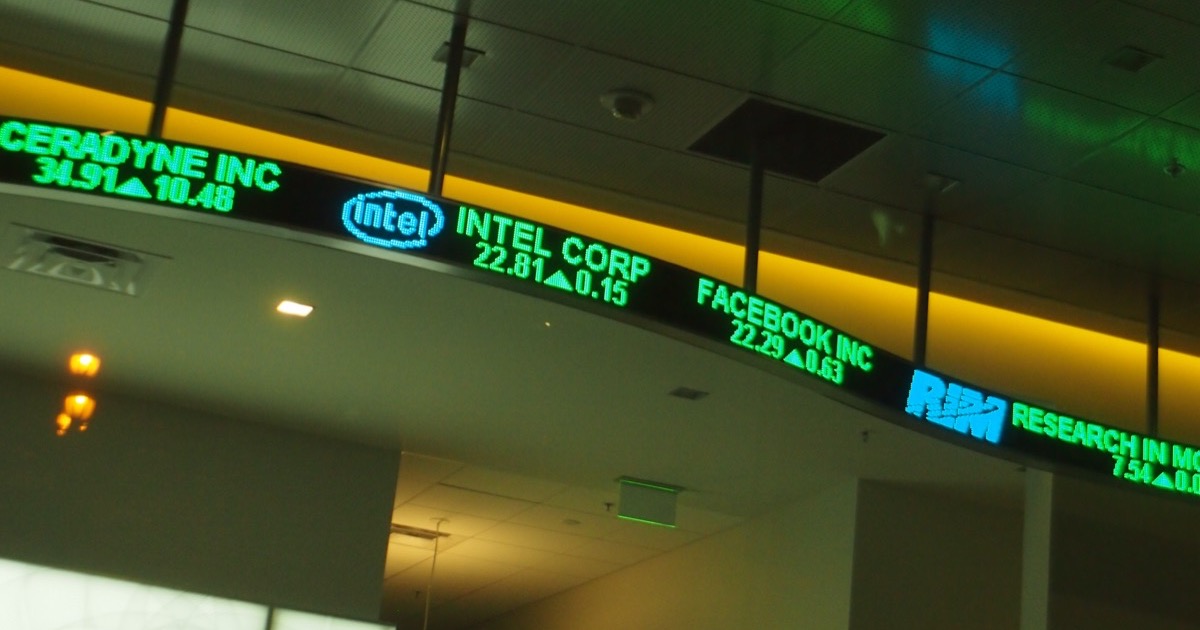 Overhead LED stock ticker showing quotes for Intel, Facebook and since-delisted companies — the pitfalls of revised and survivorship-biased data