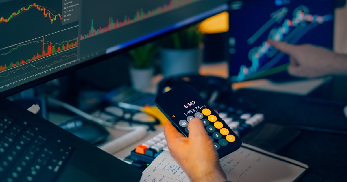 Trader reviewing stock-market charts and calculations before the opening bell