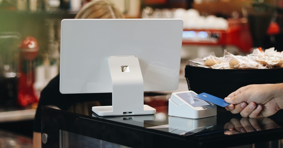 A customer taps a credit card at a retail payment terminal before the July retail sales report on August 14, 2026.