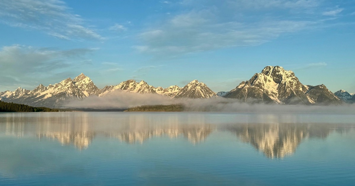 Mist rests over Jackson Lake and the Teton Range near the Jackson Hole symposium as markets wait for Federal Reserve guidance.