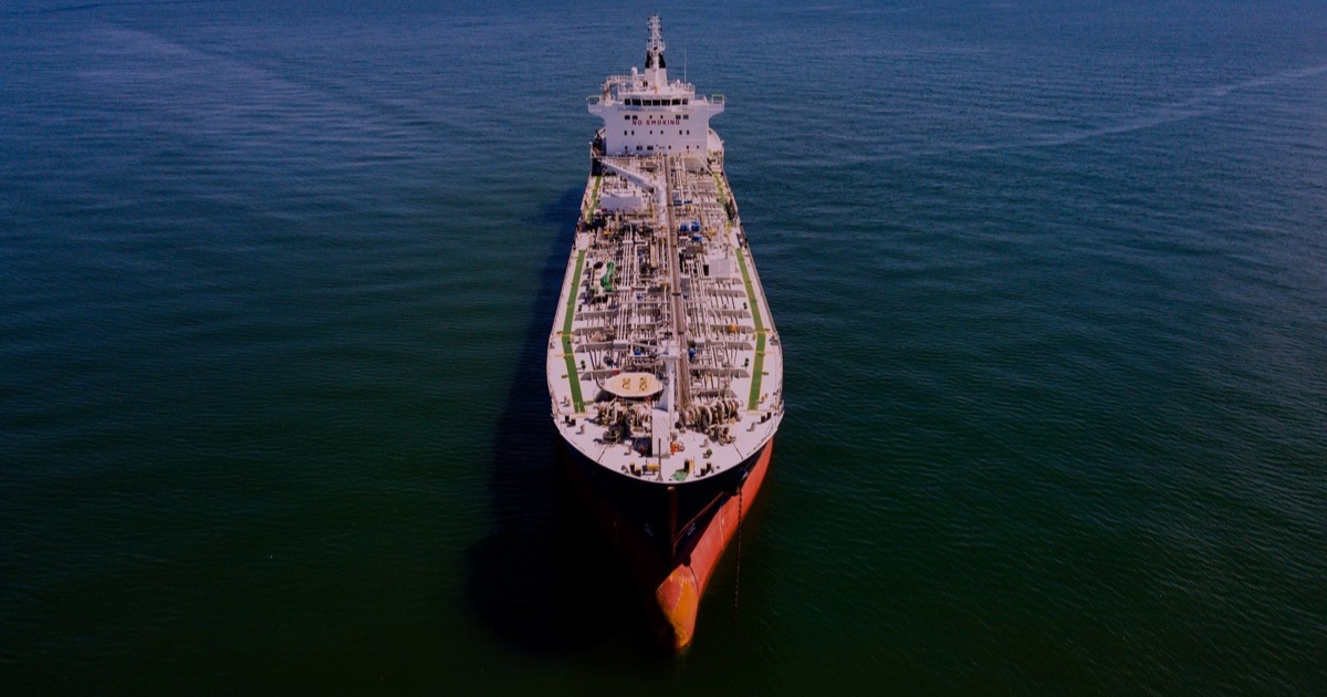An oil tanker crosses dark blue open water as renewed Strait of Hormuz risk drives crude prices higher before Monday's U.S. session.