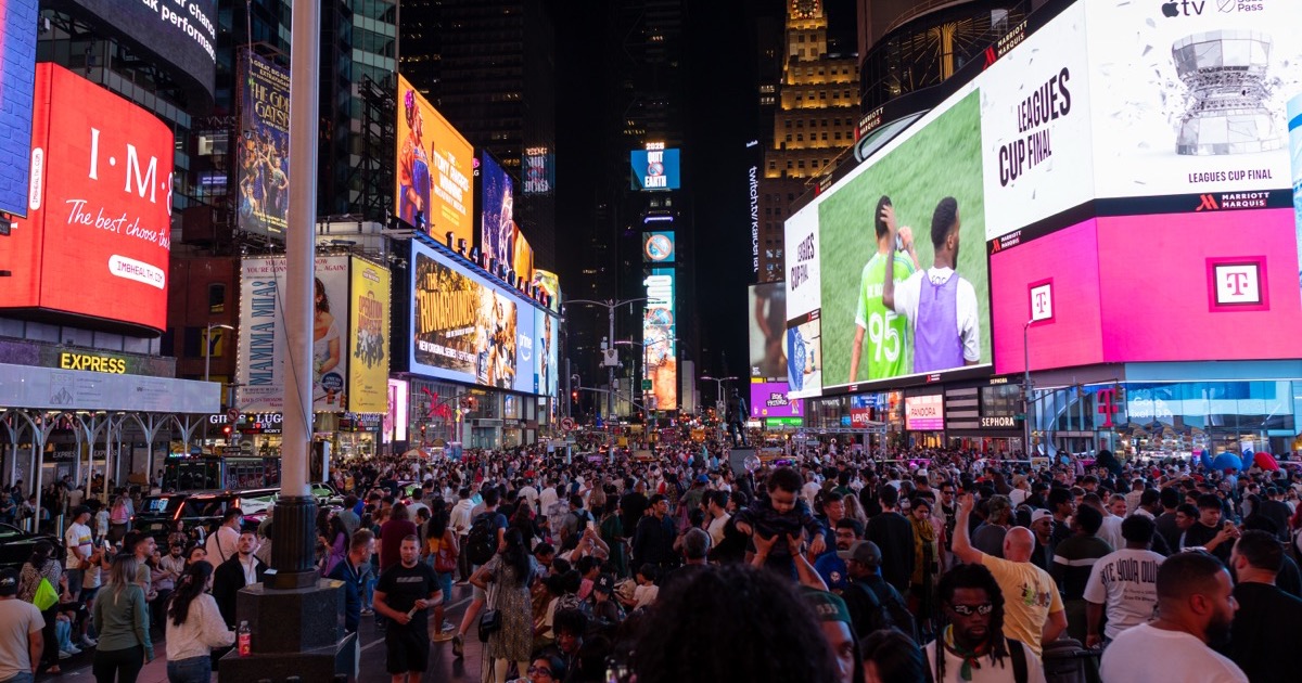 Times Square in New York lit up at night with crowds, on the morning of August 5, 2026.