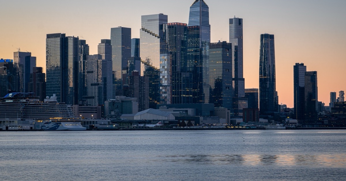 A sunrise skyline over a financial district waterfront, matching the June 15, 2026 AlphaEdge morning update on the Iran deal, falling oil and rising U.S. futures.
