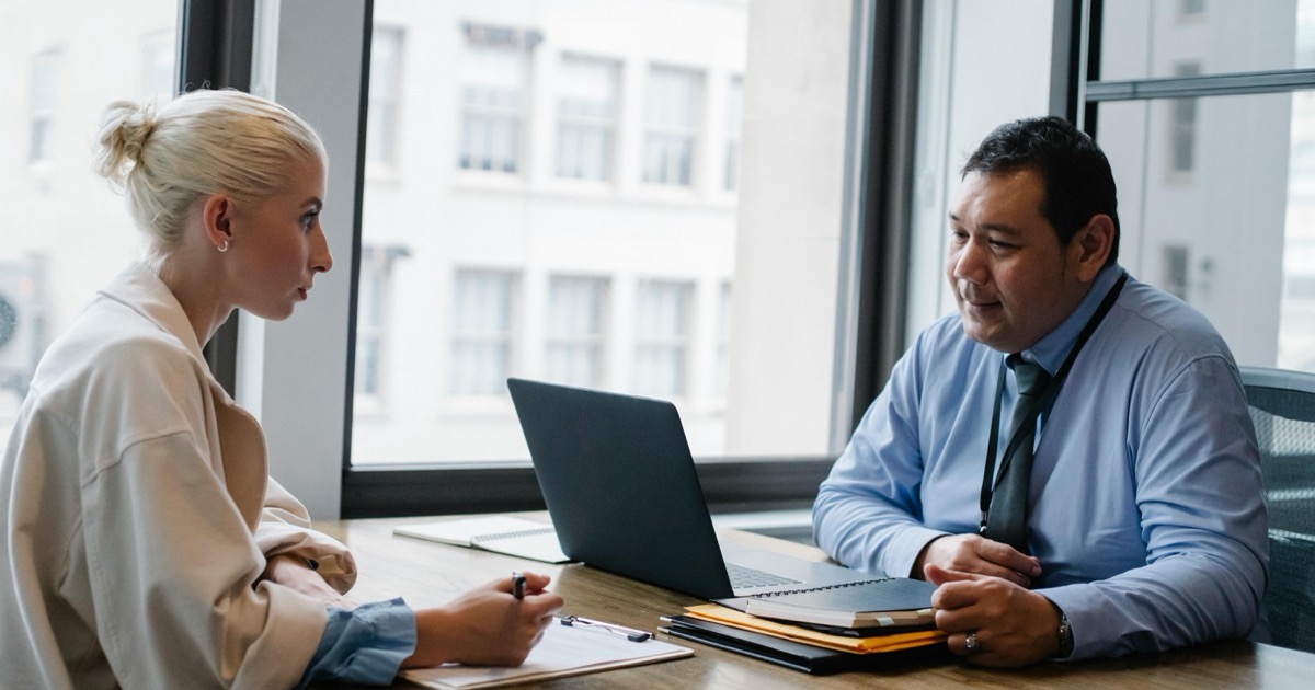 A hiring manager interviewing a job candidate at an office desk, symbolizing the JOLTS job openings report that opens jobs week on June 2, 2026.