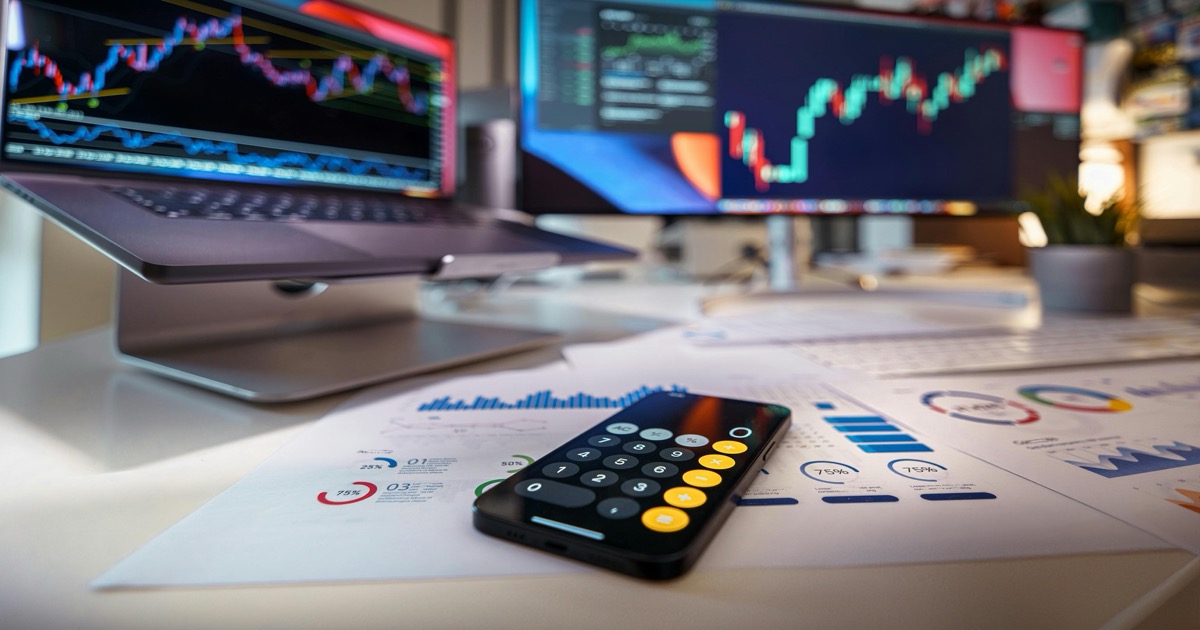 A desk with financial charts, a calculator and market notes, symbolizing the June 5, 2026 payrolls test for stock futures and AI rotation.