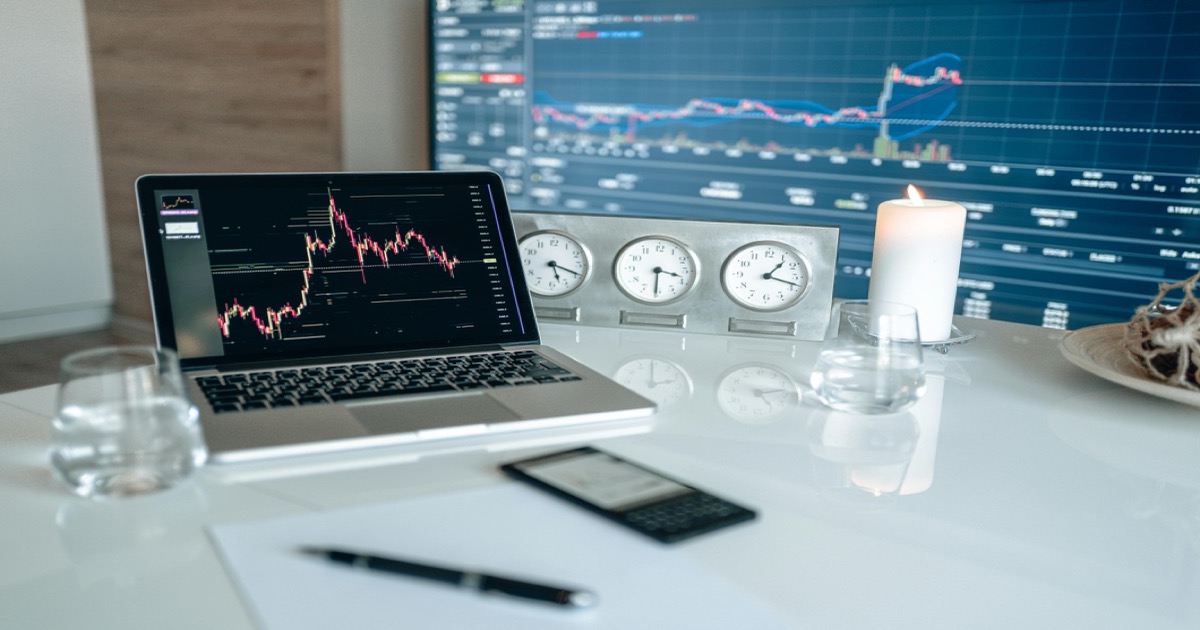 A morning trading desk with a laptop, market charts, a smartphone and clocks before the May 26 U.S. market open.