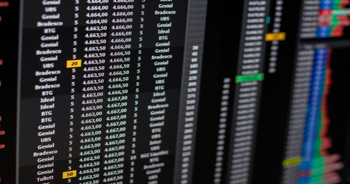 A close-up trading monitor shows flashing market data and charts before the May 27 AlphaEdge morning update.