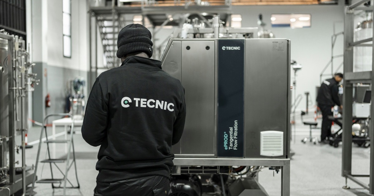 A technician works beside industrial machinery as stronger factory data, higher oil, and rising bond yields shape Tuesday's U.S. market setup.