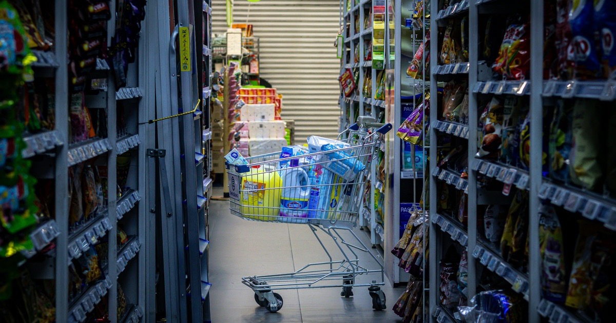 A shopping cart in a grocery aisle represents the consumer prices at the center of the market session.