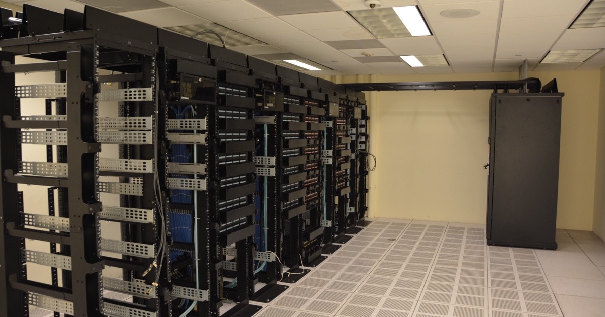 Rows of server racks inside a data center, illustrating the enterprise AI inference shift toward cheaper Chinese open-weight models