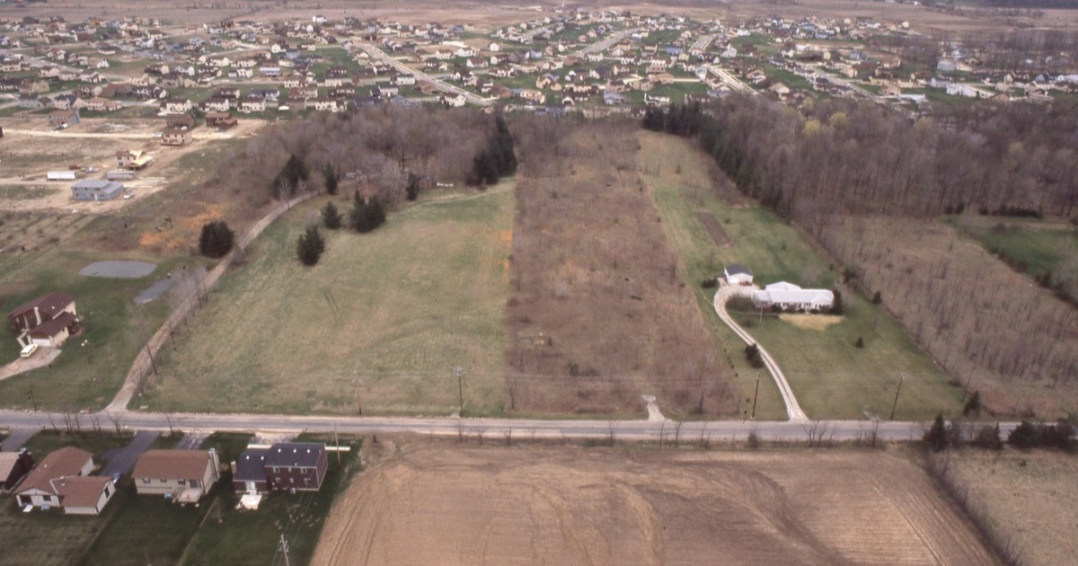 Aerial view of a US suburban housing neighborhood, illustrating the frozen 2026 housing market and the REIT sector split
