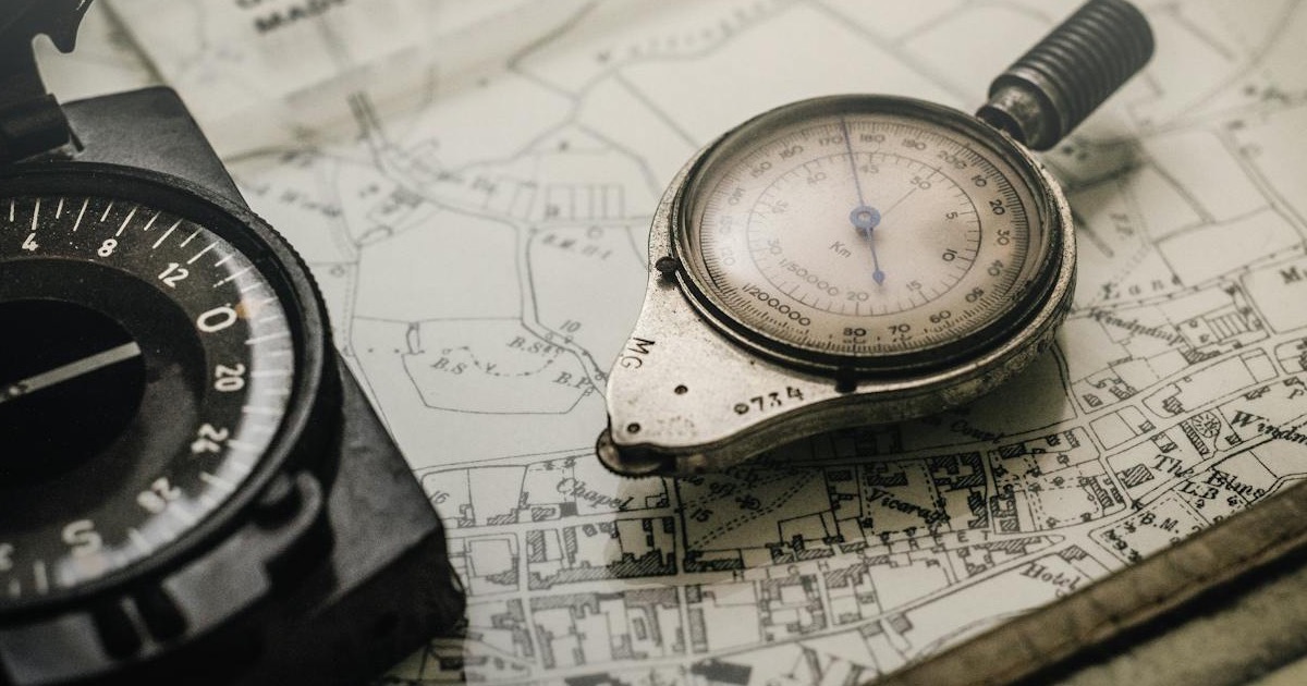 Vintage compass and navigation instrument on a map &mdash; planning the week ahead.