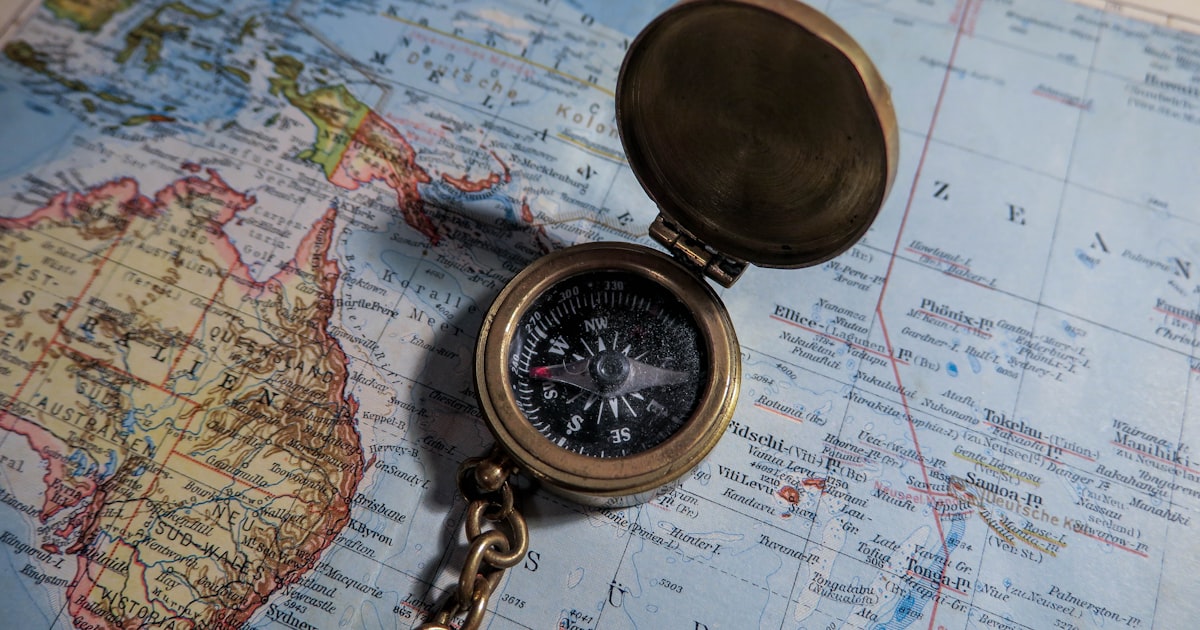 Brass compass on a vintage map symbolizing market navigation during the ceasefire week