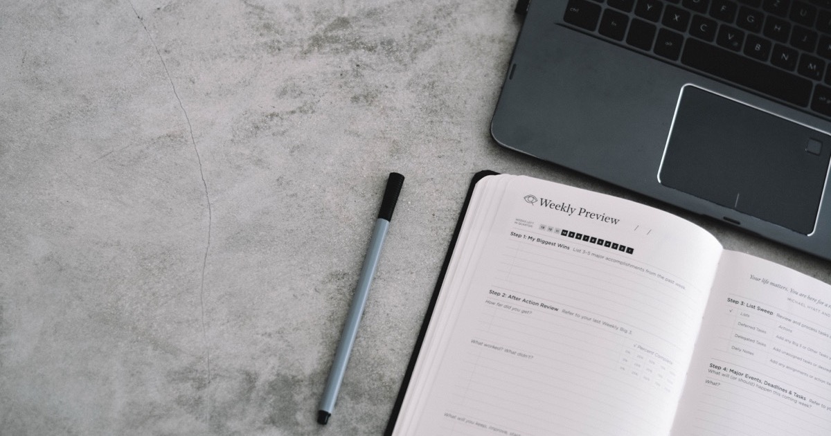 A laptop, weekly planner and pen on a desk, symbolizing the June 1-5, 2026 market week and the planning needed after the payrolls-led AI reset.